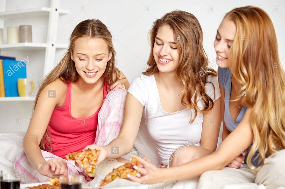 happy-friends-or-teen-girls-eating-pizza-at-home-FXW5J3